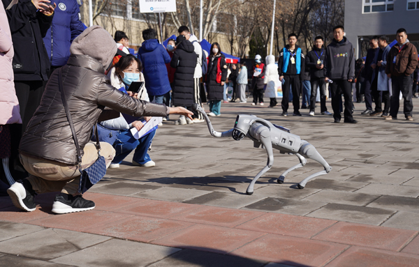 集成电路学院展示的机器狗向考生和家长举手示意。英国上市公司官网365供图
